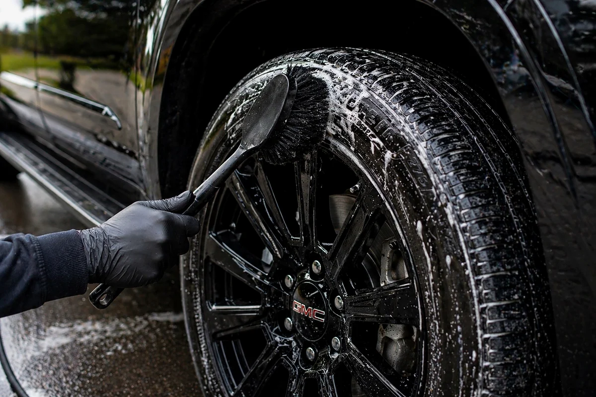 Wheel and tire being cleaned with brush